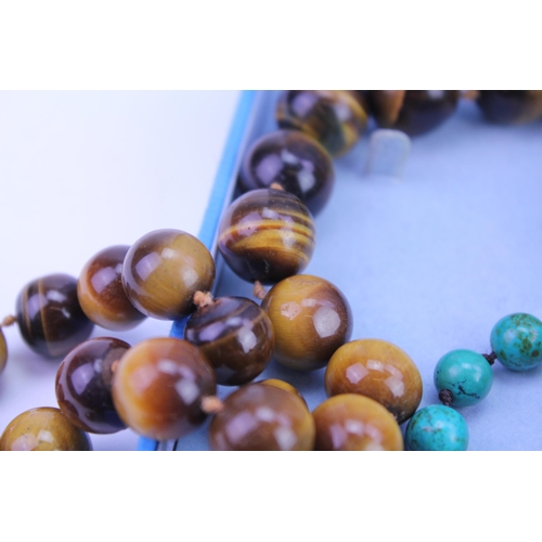 132 - A tiger eye bead necklace, two strings of beads, along with other items of costume jewellery.