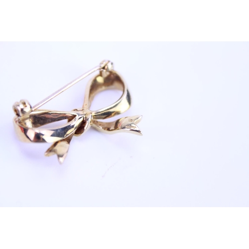 94 - A Ladies 9ct Gold Bow Brooch. Weighing: 5.2 grams. Along with a Beed Necklace.