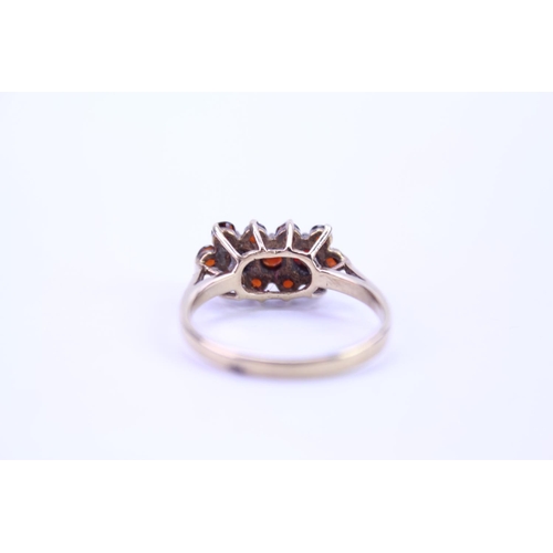 109 - A ladies 9ct Gold dress ring set with garnets in the shape of flowers. Size approx P.