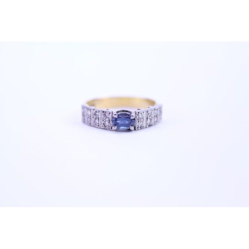 121 - A 18ct Gold dress ring set with a Sapphire and surrounding diamonds. Size approx N.