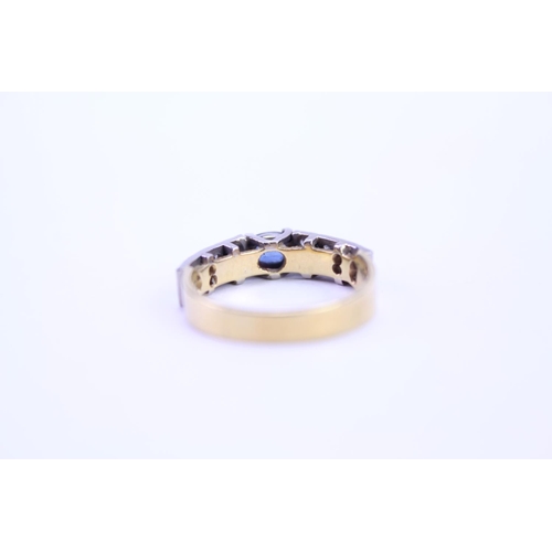 121 - A 18ct Gold dress ring set with a Sapphire and surrounding diamonds. Size approx N.