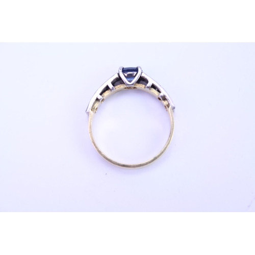 121 - A 18ct Gold dress ring set with a Sapphire and surrounding diamonds. Size approx N.