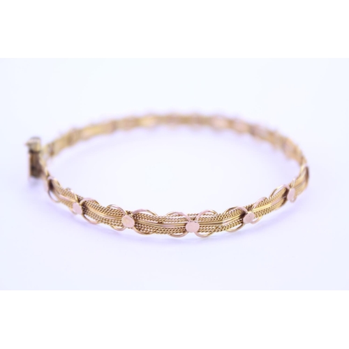 130 - An 18ct yellow Gold bangle in the filigree design. Weight approx: 6.3 grams.