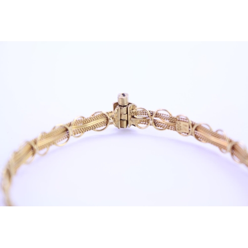 130 - An 18ct yellow Gold bangle in the filigree design. Weight approx: 6.3 grams.