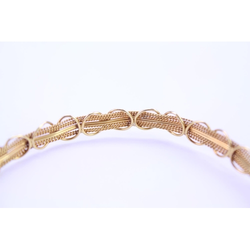 130 - An 18ct yellow Gold bangle in the filigree design. Weight approx: 6.3 grams.