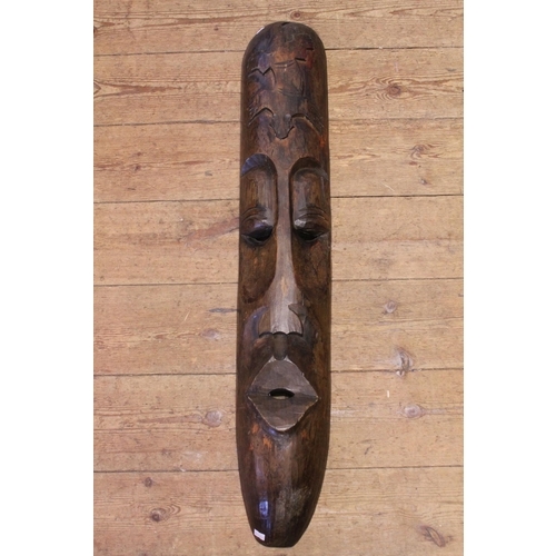 567 - A Carved Wood Elongated Lizard decorated Fang Mask. Measuring: 100cms.