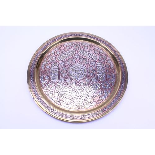 422 - A Cairo ware brass and copper inlaid metal tea tray decorated with verse and flowers.