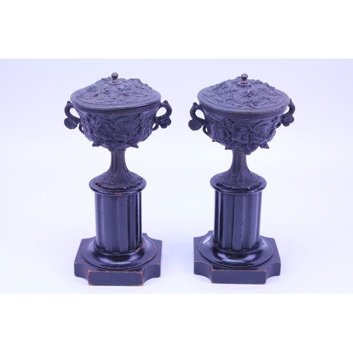 414 - A Pair of French metal mounted Urns resting on wooden supports.