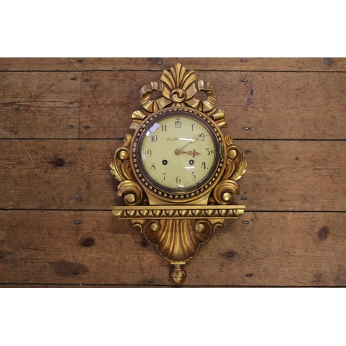 295 - A German Gilt Wood Wall Clock with carved decoration, painted face, black numeral's by Em. Soderlund... 