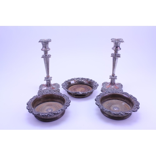 66 - Three Silver Plate on Copper Coasters along with a pair of Silver Plate on Copper Candlesticks.