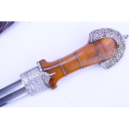 384 - A Khanjar Dagger in a Silver Coloured White Metal Filigree Sheath, Amber coloured handle, Wirework d... 