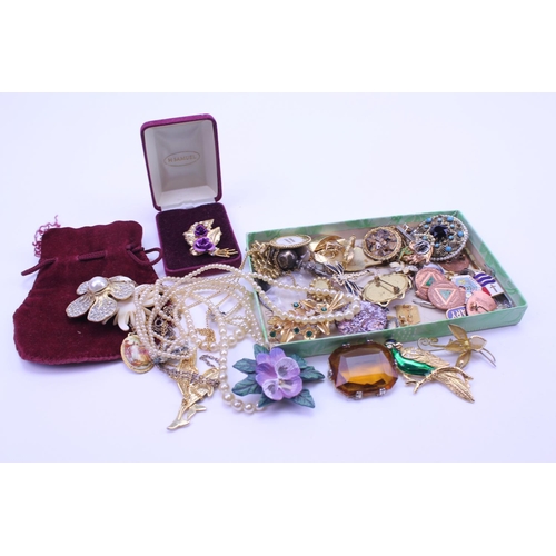 191 - A collection of costume jewellery to include brooches, earrings, badges, etc.