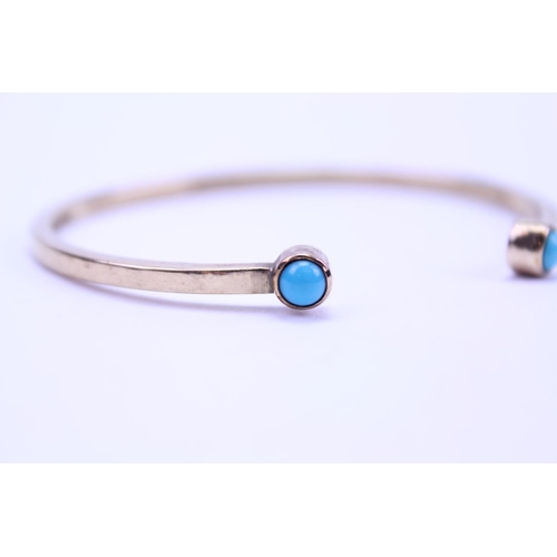 214 - A Ladies 9ct Gold Turquoise Set Bangle. Weighing: 14 grams.