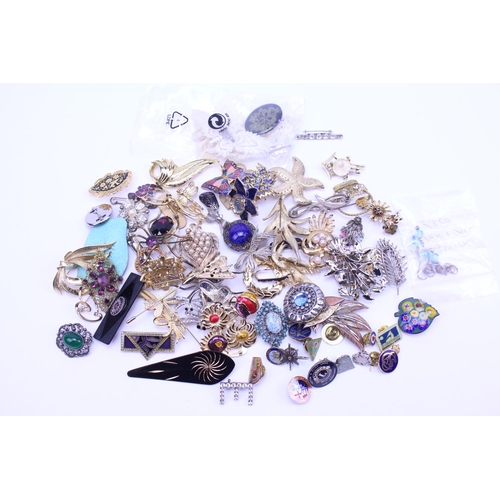 149 - A quantity of costume jewellery to include badges, brooches, etc.