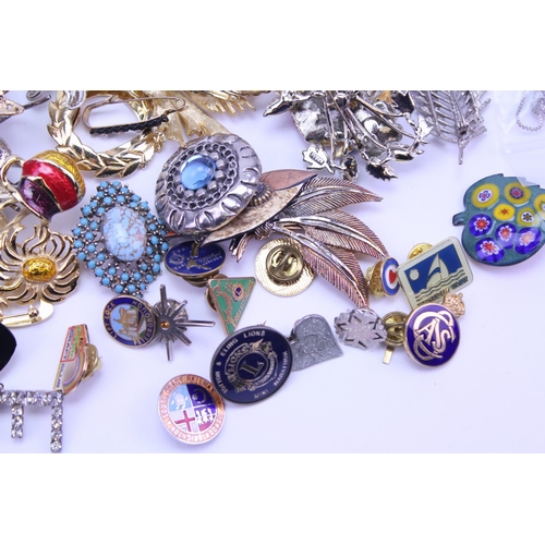 149 - A quantity of costume jewellery to include badges, brooches, etc.