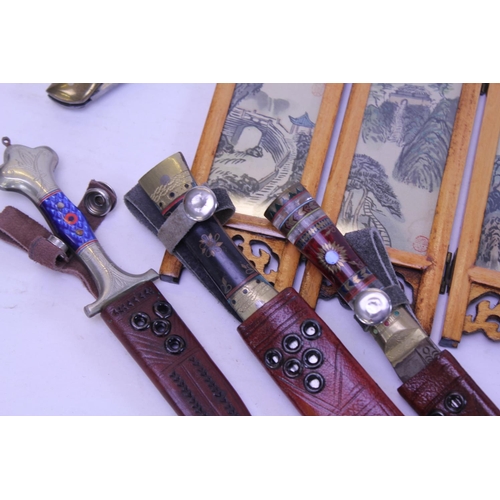 888 - A Chinese Three Fold Screen, Three various Brass mounted Daggers & a Paper Knife.