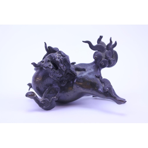 906 - An Chinese bronze study of a Foo dog. AF. Size approx 11cm.