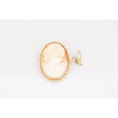 230 - A 9ct Gold Cameo Brooch of a Young Girl gazing at a Flower. Weighing: 11 Grams (Gross).