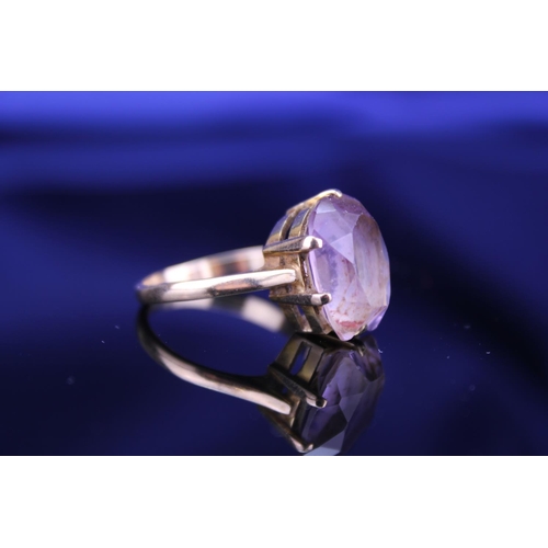 233 - A 9ct Gold Dress Ring mounted with a Purple Stone. Size: Q. Weighing: 5.2 grams Gross.