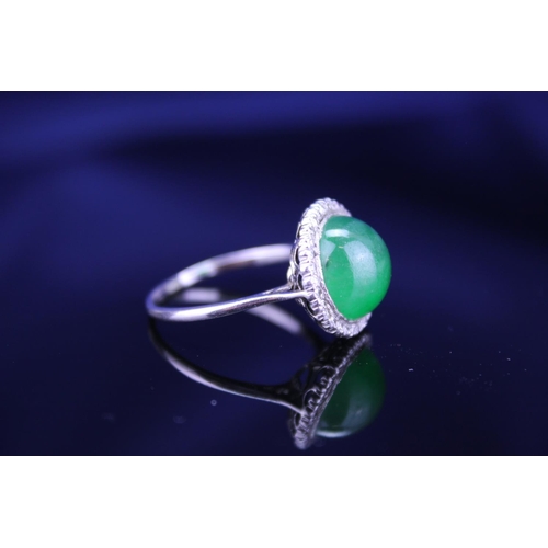 257 - A Beautiful jade cabochon ring surrounded by small diamonds. Size approximately 0.5cm deep x 0.8cm d... 