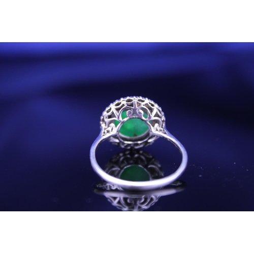 257 - A Beautiful jade cabochon ring surrounded by small diamonds. Size approximately 0.5cm deep x 0.8cm d... 