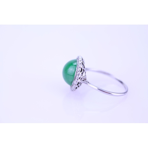 257 - A Beautiful jade cabochon ring surrounded by small diamonds. Size approximately 0.5cm deep x 0.8cm d... 