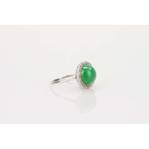 257 - A Beautiful jade cabochon ring surrounded by small diamonds. Size approximately 0.5cm deep x 0.8cm d... 