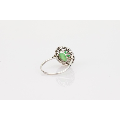 257 - A Beautiful jade cabochon ring surrounded by small diamonds. Size approximately 0.5cm deep x 0.8cm d... 