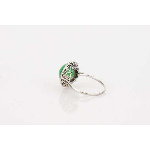 257 - A Beautiful jade cabochon ring surrounded by small diamonds. Size approximately 0.5cm deep x 0.8cm d... 