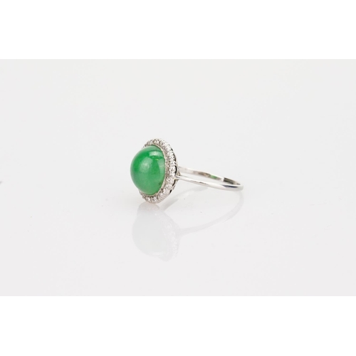 257 - A Beautiful jade cabochon ring surrounded by small diamonds. Size approximately 0.5cm deep x 0.8cm d... 