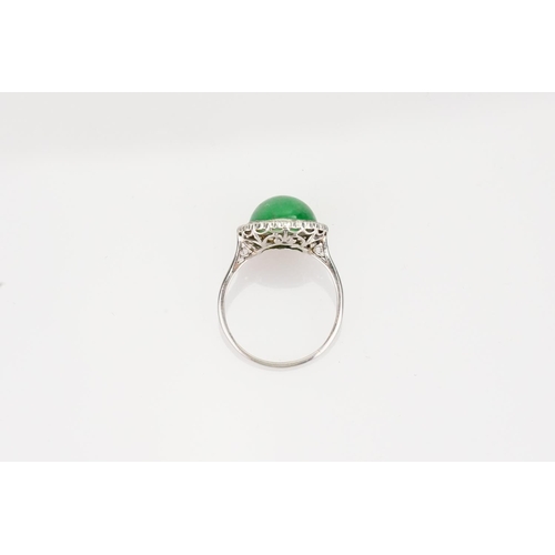 257 - A Beautiful jade cabochon ring surrounded by small diamonds. Size approximately 0.5cm deep x 0.8cm d... 