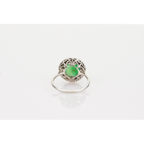 257 - A Beautiful jade cabochon ring surrounded by small diamonds. Size approximately 0.5cm deep x 0.8cm d... 