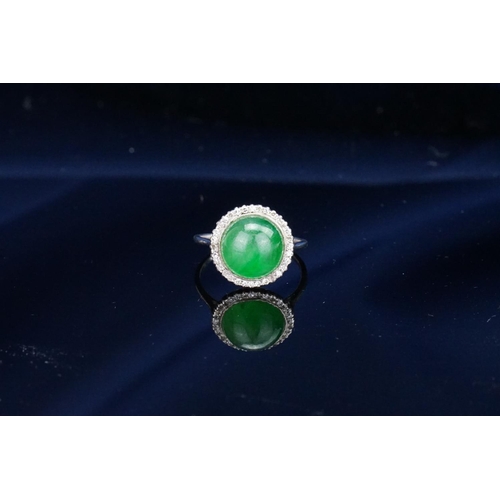 257 - A Beautiful jade cabochon ring surrounded by small diamonds. Size approximately 0.5cm deep x 0.8cm d... 