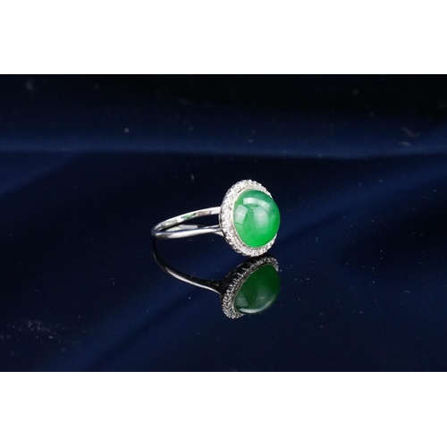 257 - A Beautiful jade cabochon ring surrounded by small diamonds. Size approximately 0.5cm deep x 0.8cm d... 