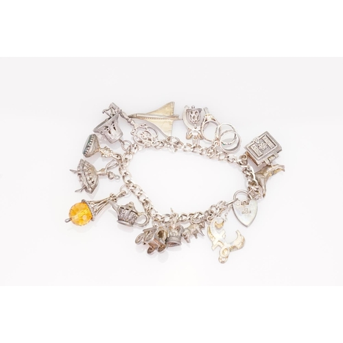 219 - A Silver charm bracelet fitted with various charms including Concorde, ballerina, etc.