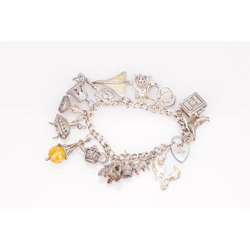 219 - A Silver charm bracelet fitted with various charms including Concorde, ballerina, etc.