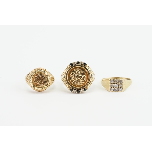 63 - Three 9ct Gold Dress Rings mounted with Stones & Medallions. Weighing: 9.9 grams.