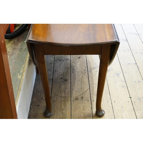 406 - A George II Mahogany Drop-Flap Circular Top Dining Table resting on Pad Feet. Measuring: 144cms long... 