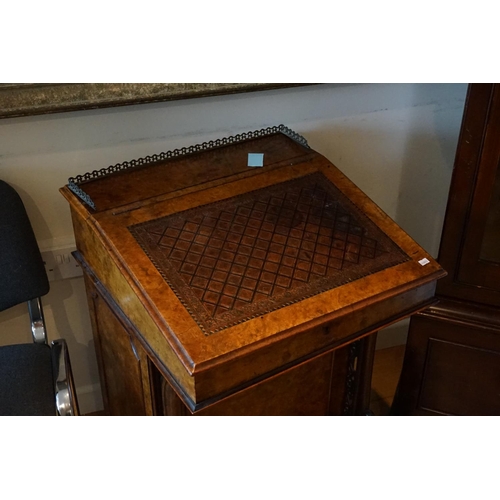 595 - A Victorian bure walnut veneered davenport with fitted interior. Resting on a carved pierced column.... 