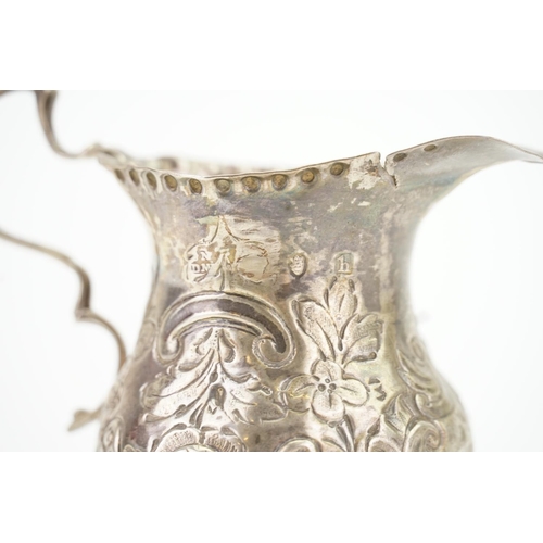 37 - A Georgian Silver Cream Jug with embossed decoration. (AF). Weighing: 60 grams.