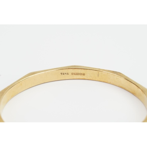 114 - A 9ct Gold Decagon engraved Bangle. Weighing: 13.1 grams.