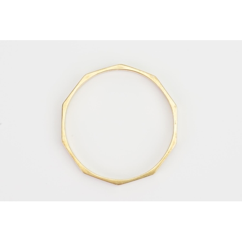 114 - A 9ct Gold Decagon engraved Bangle. Weighing: 13.1 grams.