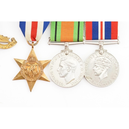 664 - An Artillery Cap Badge along with a Set of Three WWII Medals.