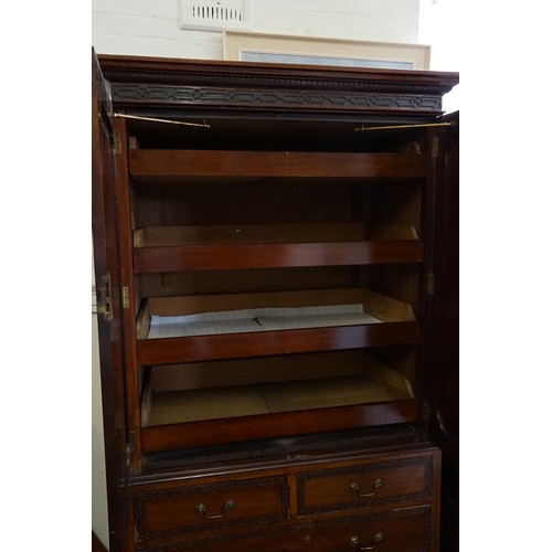 556 - An Edwardian Mahogany Linen Press with Blind Fret Carving, Swan Neck Handles & Fitted Shelves. Measu... 