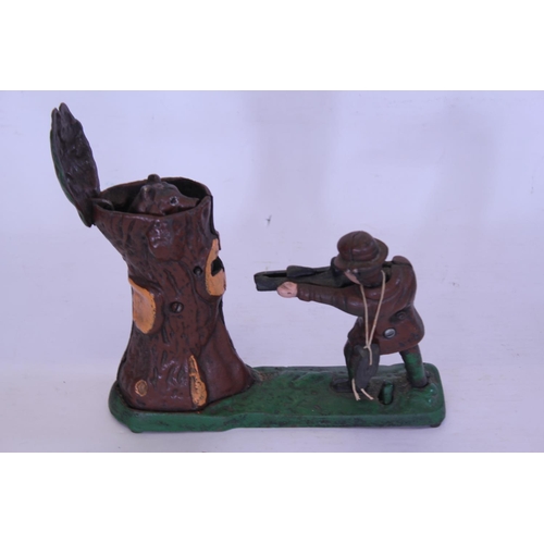 387 - A 20th Century Cast Iron Money Box Toy depicting a Man Shooting a Bear coming out of a tree stump.