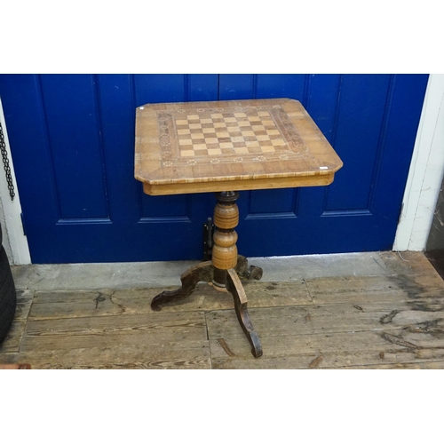 593 - An Italian walnut veneered chess top table resting on a tripod base with cut corners. Top Measuring:... 