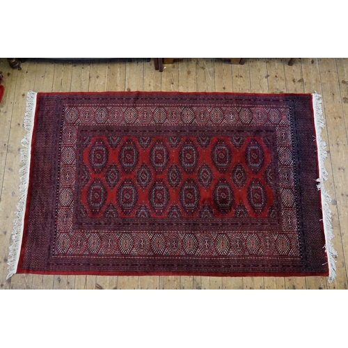 290 - A Persian design Red ground, central gold patterned, wide diaper and four line border and extended e... 