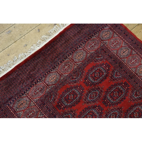 290 - A Persian design Red ground, central gold patterned, wide diaper and four line border and extended e... 