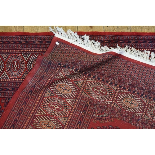 290 - A Persian design Red ground, central gold patterned, wide diaper and four line border and extended e... 