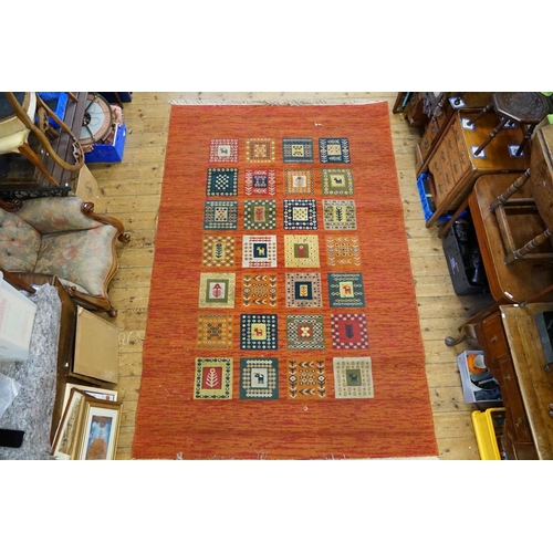 296 - A Turkish Red ground, square gul, fishtail design carpet with fringed edge. Measuring: